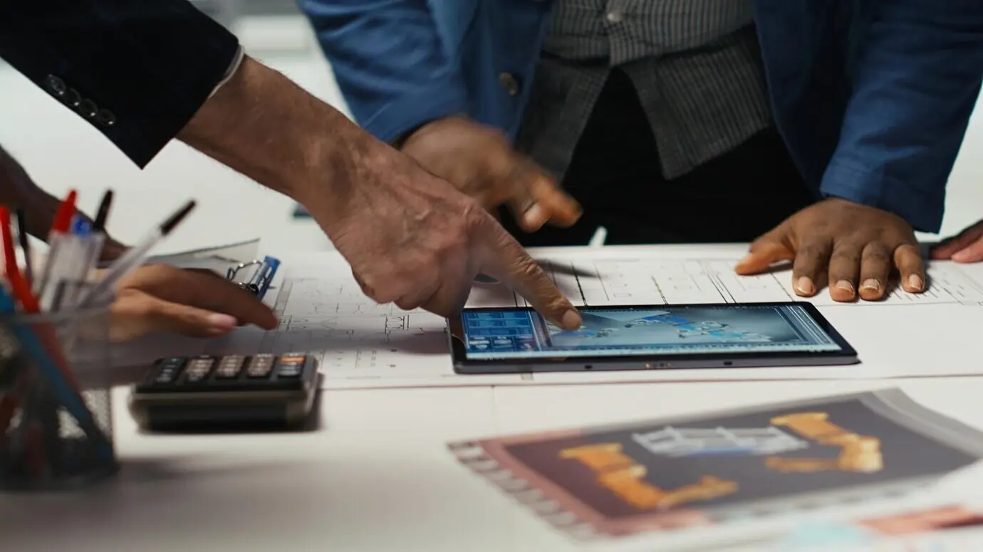 Des spécialistes d’usine conçoivent des lignes de production pour une installation d’assemblage dans un logiciel de CAO sur tablette.